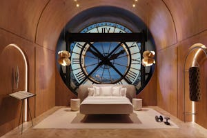 Luxurious bedroom with a large bed centered in front of a massive, round window designed to look lik...