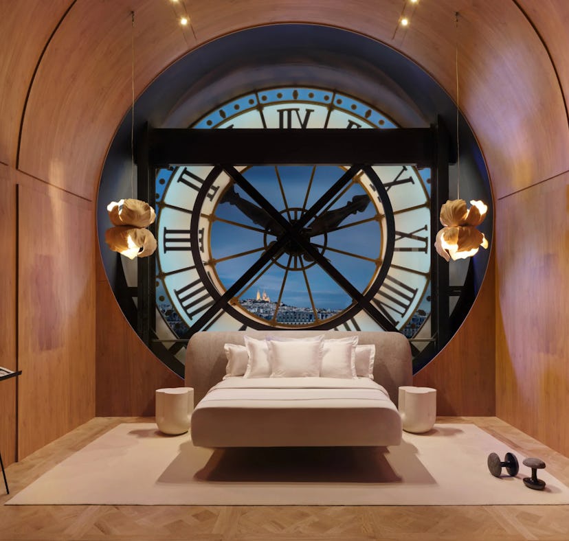 Luxurious bedroom with a large bed centered in front of a massive, round window designed to look lik...