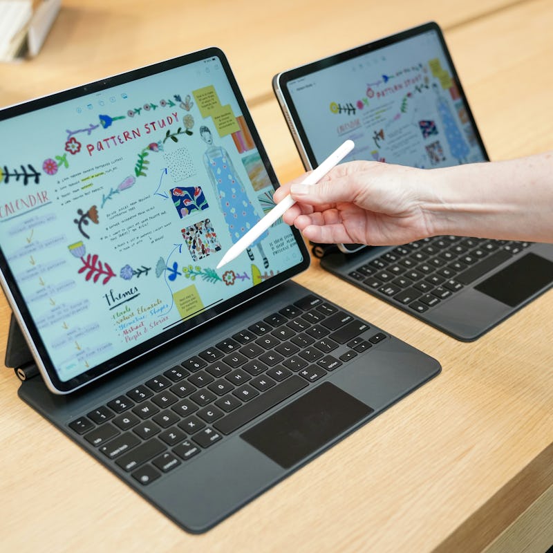 Apple's new 13-inch iPad Air and 11-inch iPad Air with M2 chips attached to Magic Keyboards.