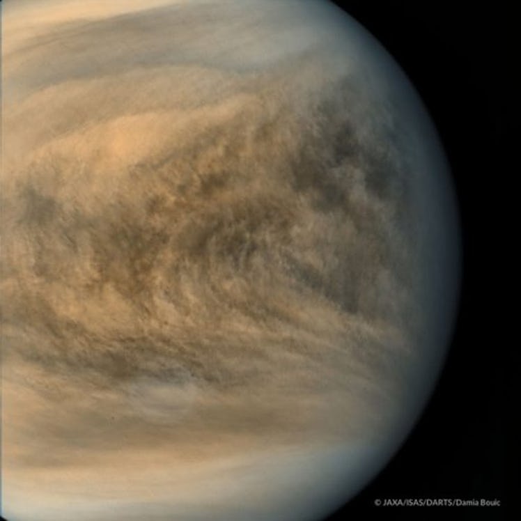 photo of a cloudy planet in shades of gray, cream, tan, and brown.