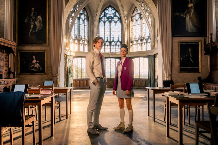 Two individuals, a man in a suit and a woman in a school uniform, stand in a grand, Gothic-style lib...