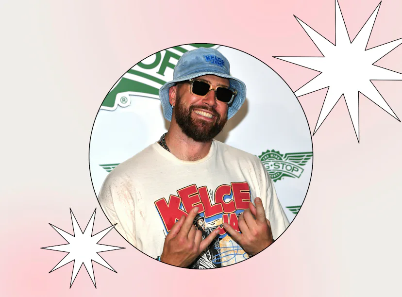 A man in a white "Kelce" T-shirt and blue bucket hat, smiling with sunglasses, making a peace sign g...