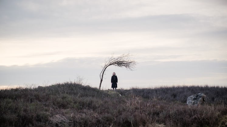 A woman stands near a lone tree in the new 'Doctor Who' episode, "73 Yards"