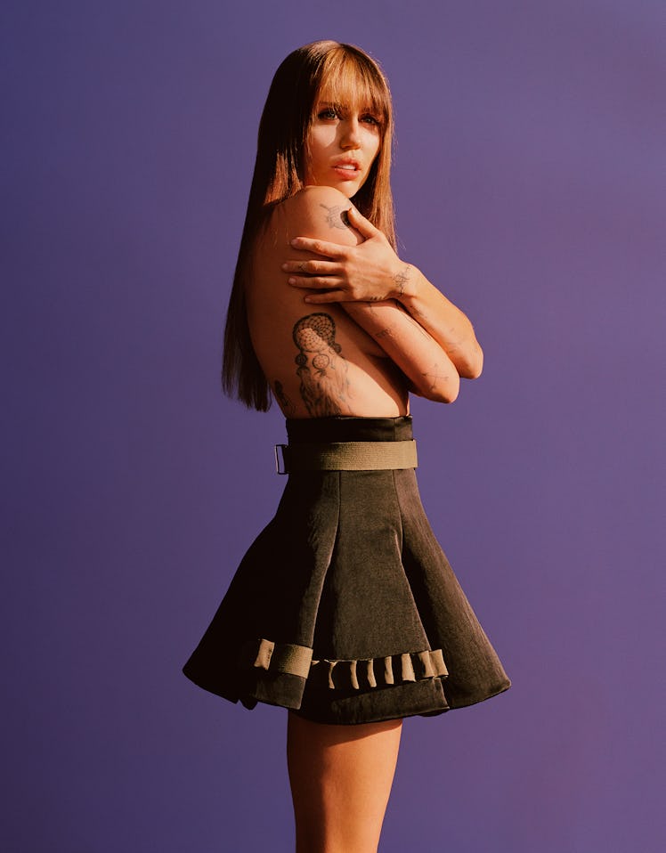 Miley Cyrus wears a black suede skirt.