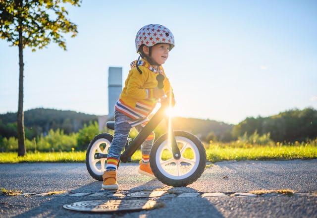 A child rides on a balance bike.