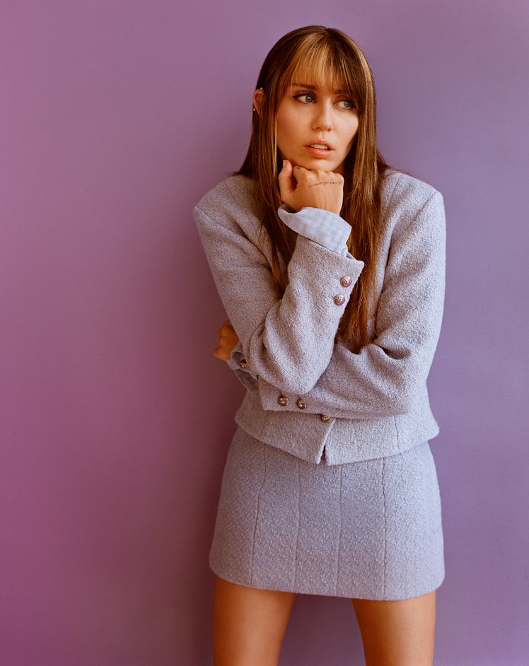 Miley Cyrus wears baby blue wool jacket and mini skirt.