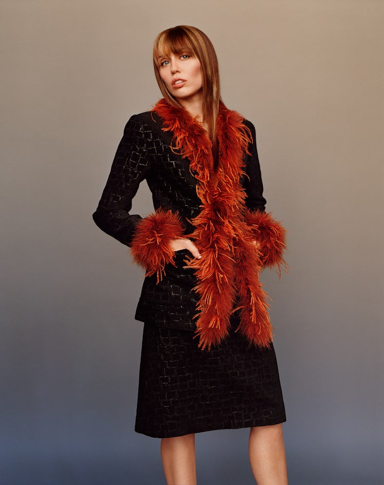 Miley Cyrus wears a black wool jacket and skirt.