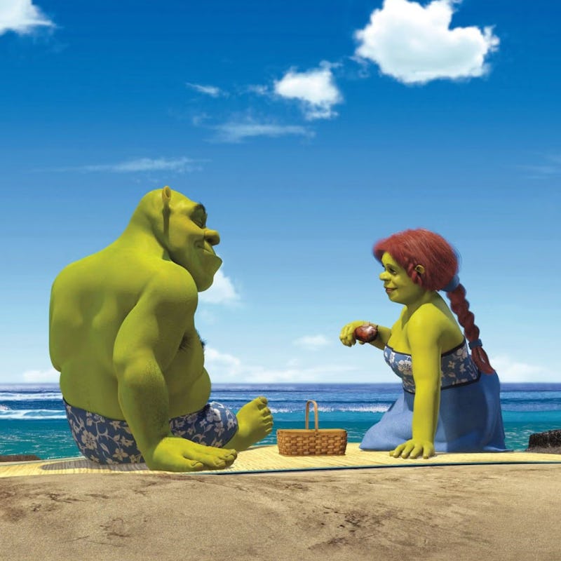Shrek and Fiona sharing a picnic on a sunny beach, with a clear blue sky and ocean backdrop.