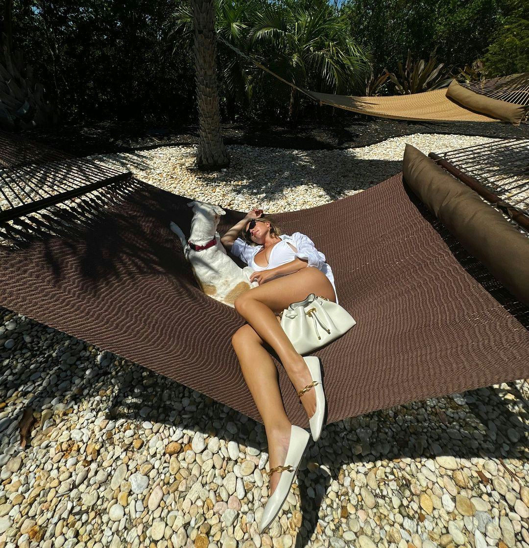 Sydney Sweeney wears a white plunging swimsuit.