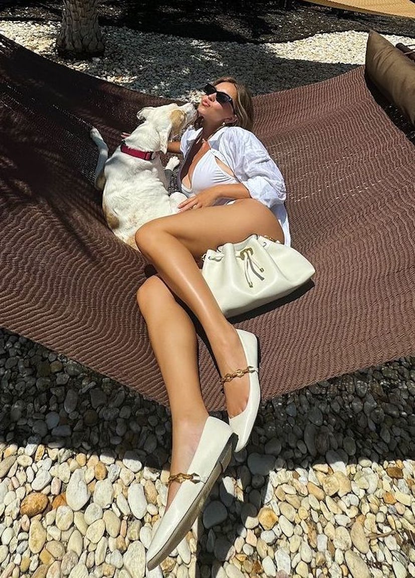 Sydney Sweeney wears a white plunging swimsuit.