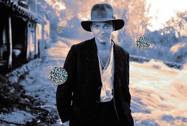 Man in a fedora and jacket stands on a country road at twilight with illustrated viruses floating ar...