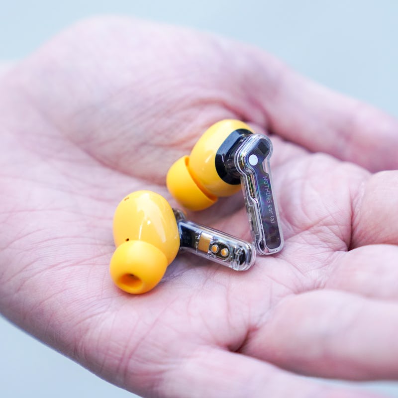 Yellow Nothing Ear A wireless earbud in a hand.