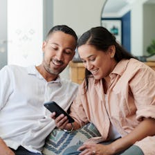 A couple looks at a smart phone together.