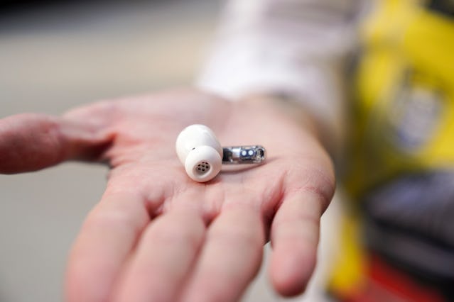 Ear wireless earbud outside of charging case.