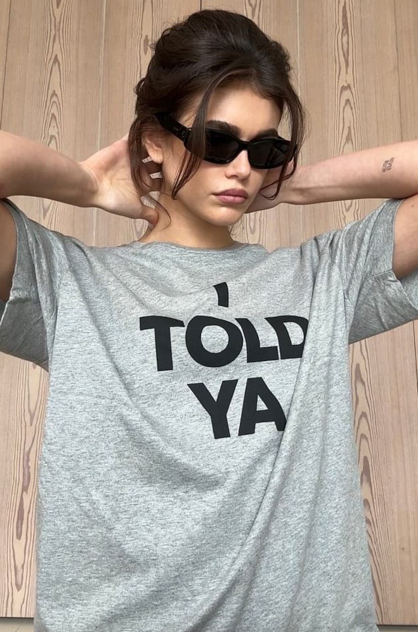 Kaia Gerber wears the Loewe “I TOLD YA” shirt.
