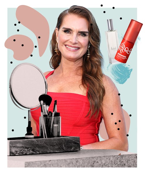 Woman in red dress with makeup products, a mirror, and skincare bottles on an abstract background.