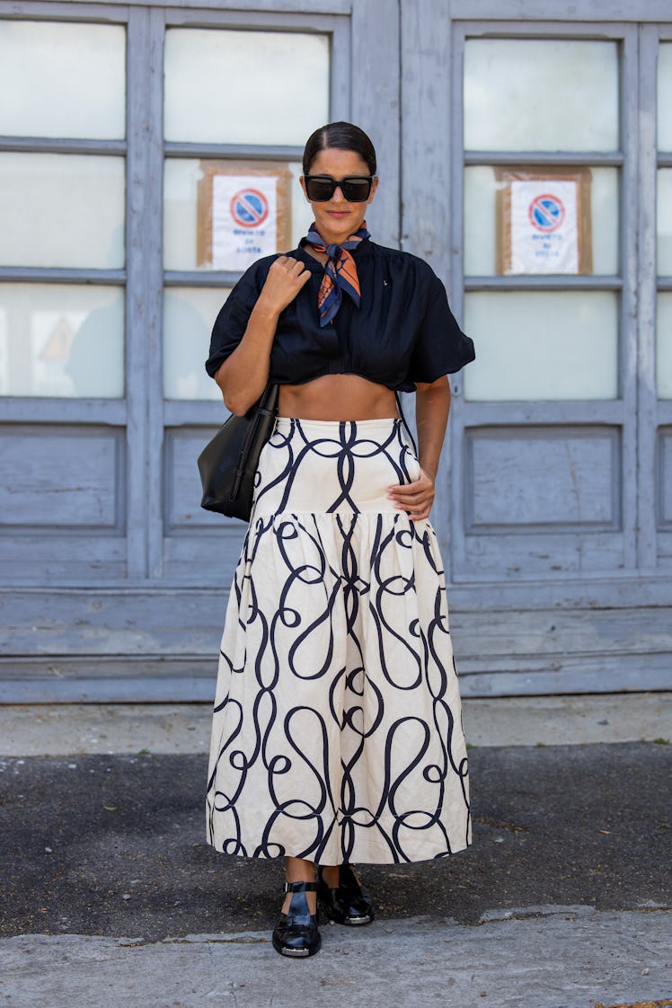 Gili Biegun wears black cropped top and white skirt with print Shona Joy, sunglasses Celine, bag Ver...