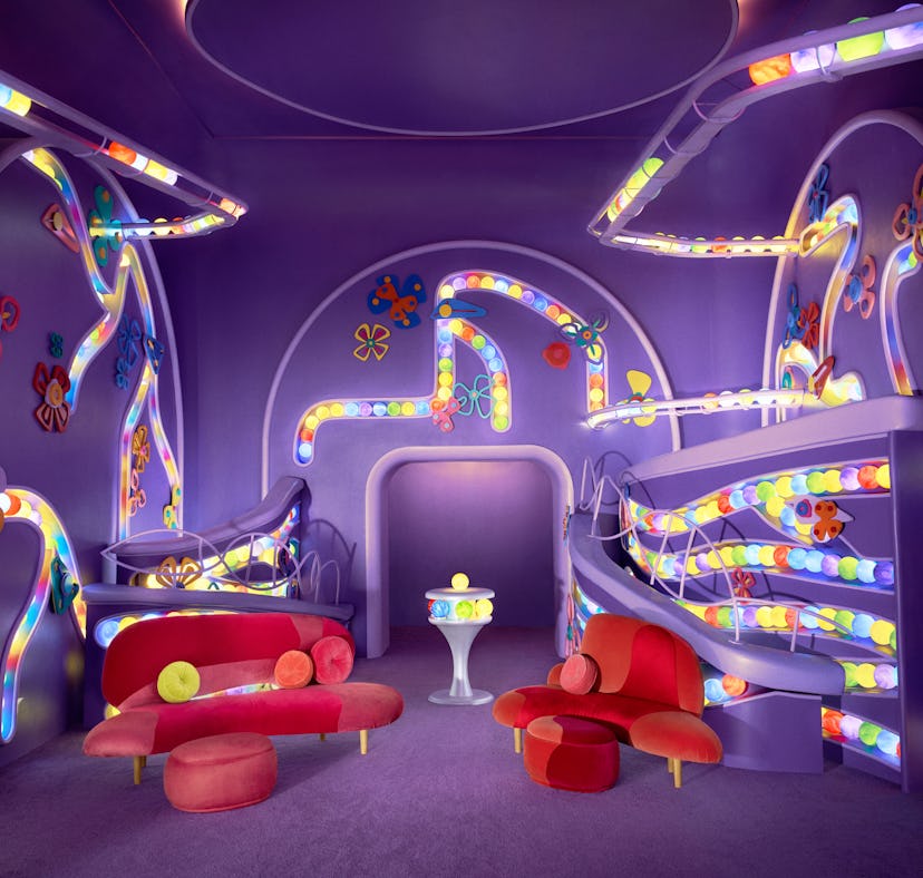 A colorful, whimsical bedroom with neon lights, bunk beds, and vibrant furniture designed for childr...