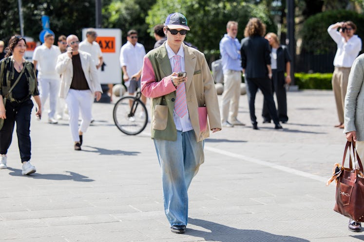 A guest wears oversized mixed colored blazer, wide leg denim jeans during Pitti Immagine Uomo 106 on...