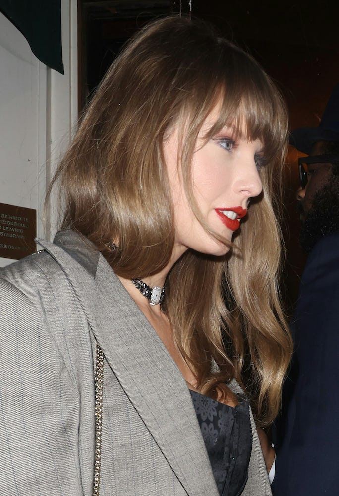Taylor Swift wears a black corset with a watch necklace