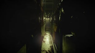 Dark, narrow corridor with dim lighting, creating a mysterious and eerie atmosphere, possibly inside a building or industrial setting.