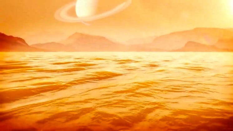 orange-tinted image of a sea, with mountains in the background and a ringed planet in the sky above