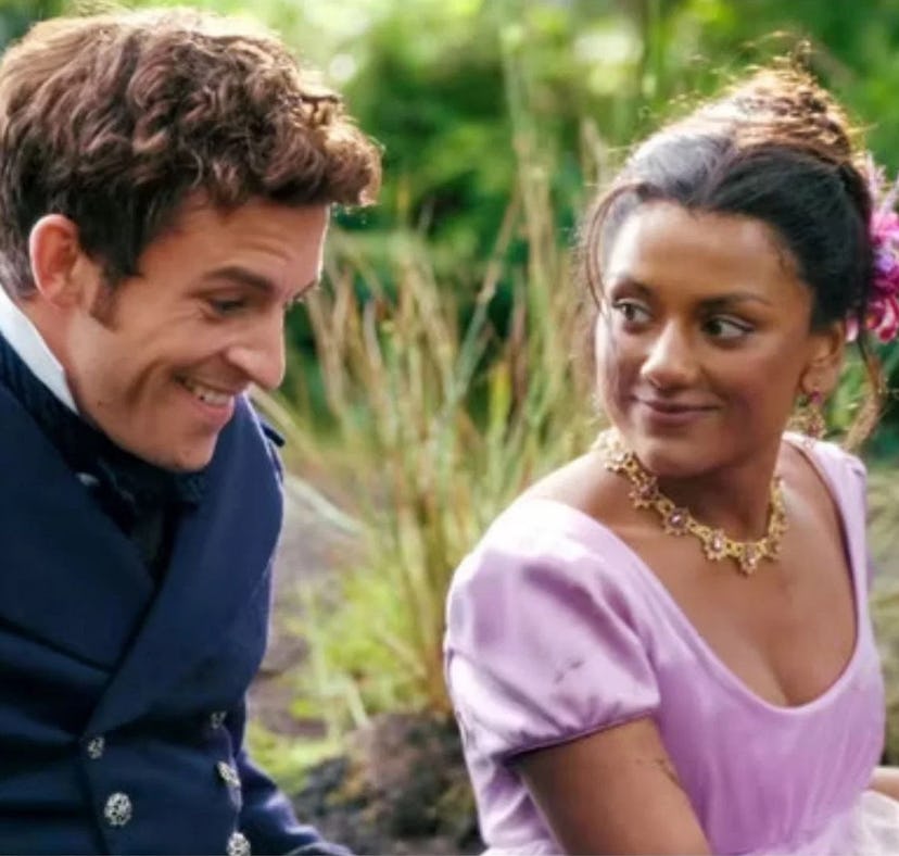 A joyful scene with a man in a navy coat and a woman in a lilac dress with a flower in her hair, bot...