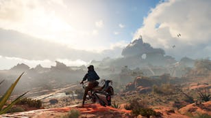 A character on a futuristic motorcycle overlooks a sprawling desert landscape with rocky formations and distant birds under a blue sky.