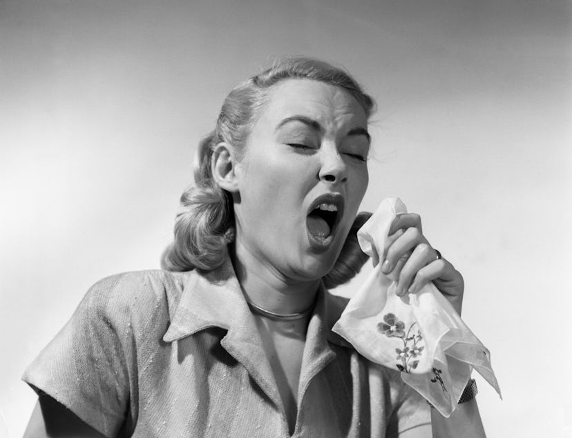 1950s WOMAN SNEEZING COUGHING INTO HANDKERCHIEF