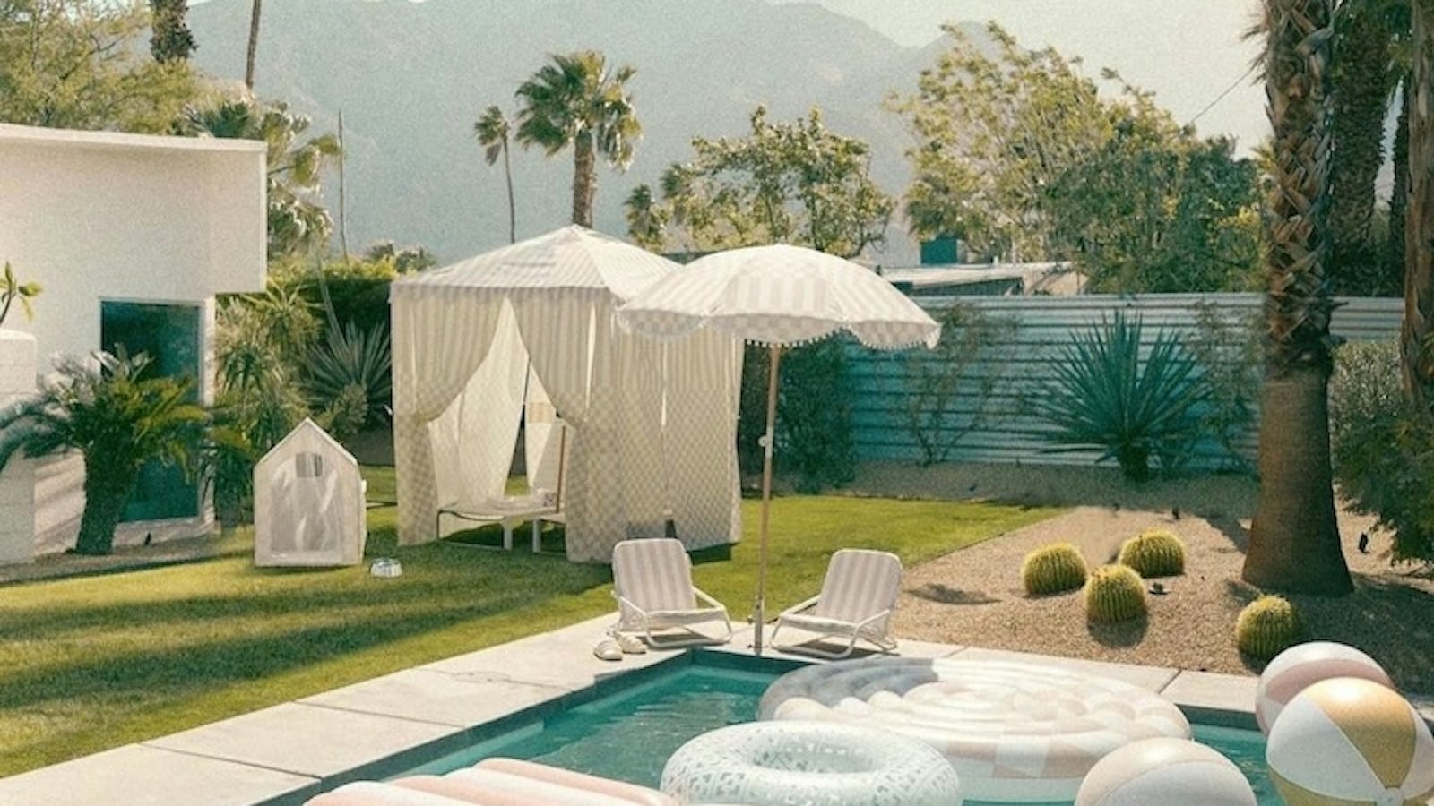 backyard with cabana, pool, and palm trees with a mountain view