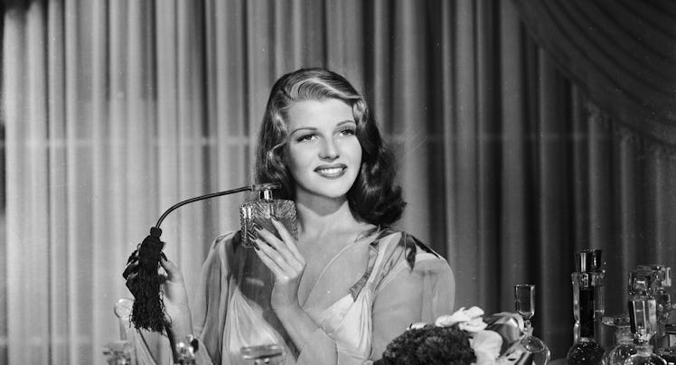 1941: American film actress, dancer and singer Rita Hayworth (1918 - 1987) sprays herself with perfu...