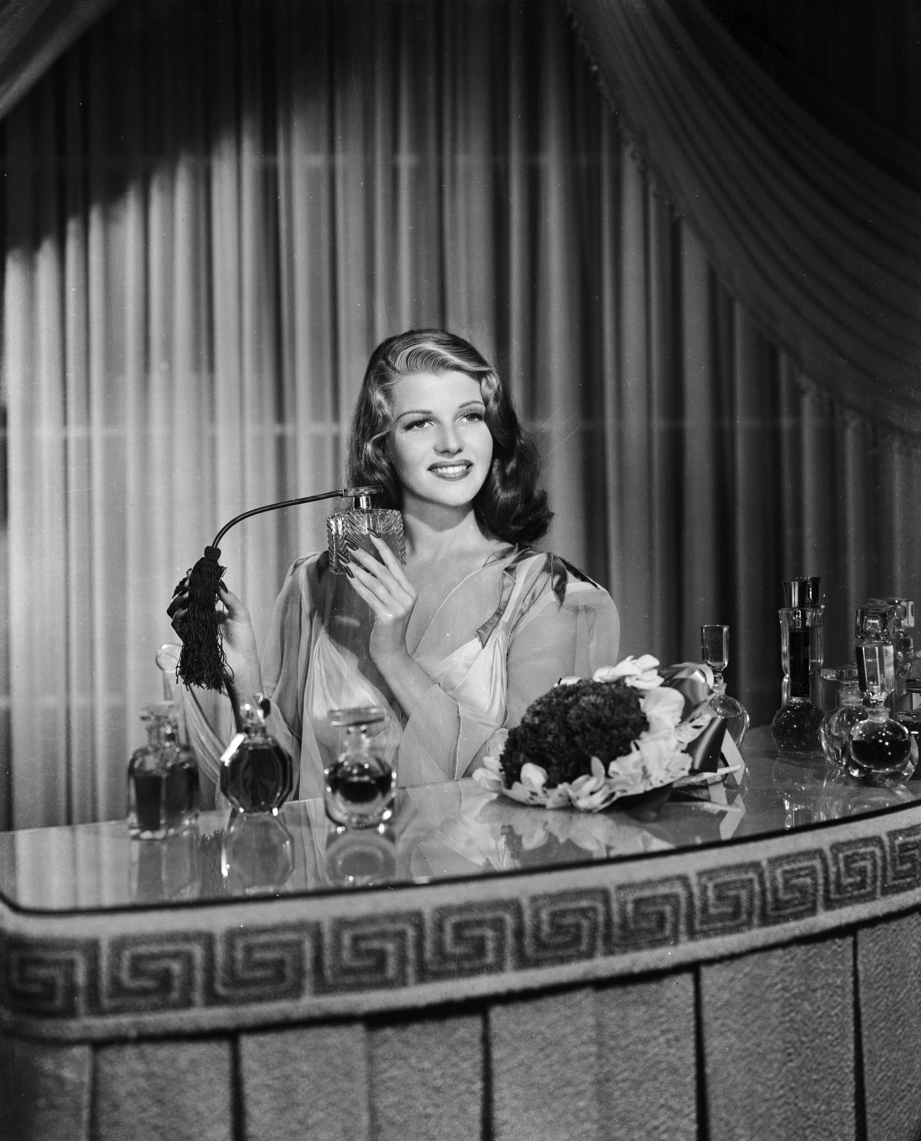 1941: American film actress, dancer and singer Rita Hayworth (1918 - 1987) sprays herself with perfu...