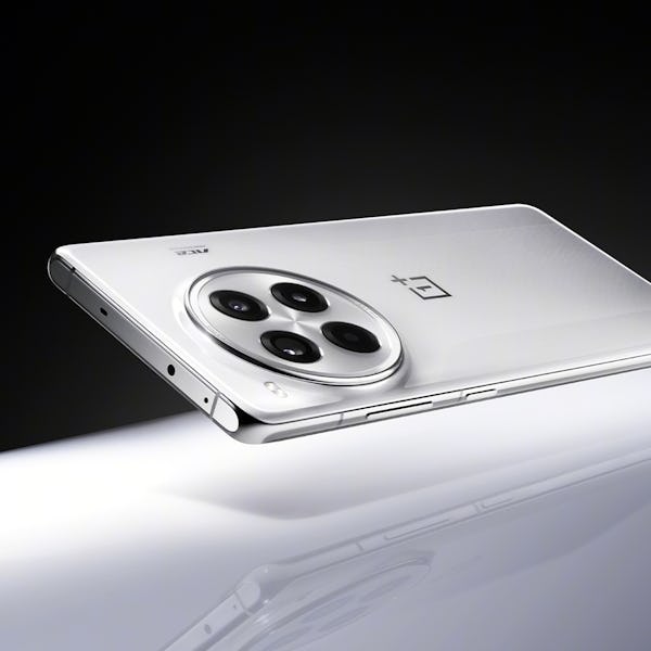 A white OnePlus smartphone with a triple camera setup on a reflective surface, partially illuminated...