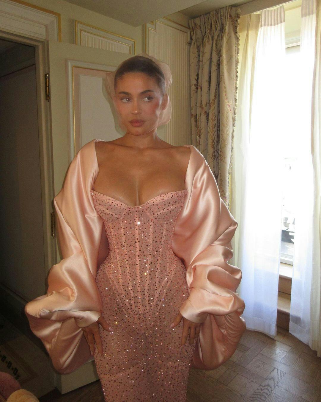 Kylie Jenner wears a strapless bustier dress with a satin cape to Paris Couture Week.