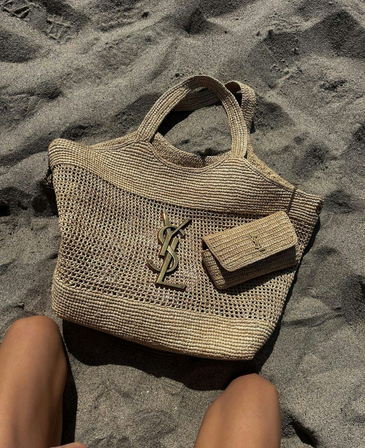 Elsa Hosk carries a raffia Saint Laurent tote to the beach.