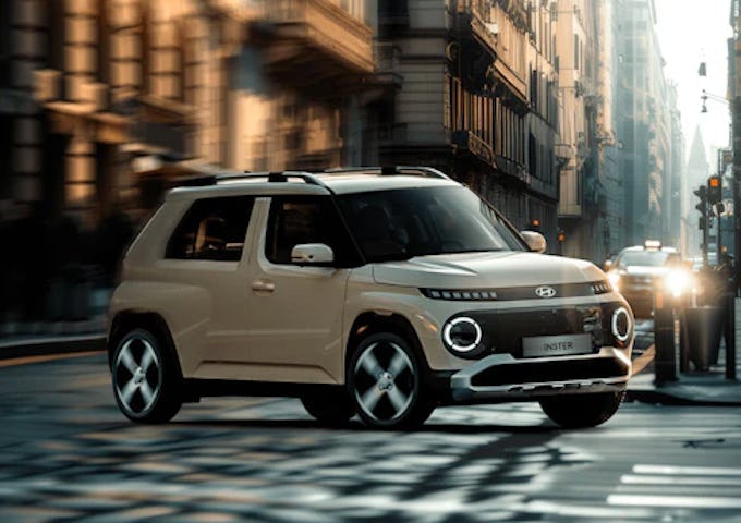 A modern beige SUV driving on an urban street bathed in soft sunlight during early morning.