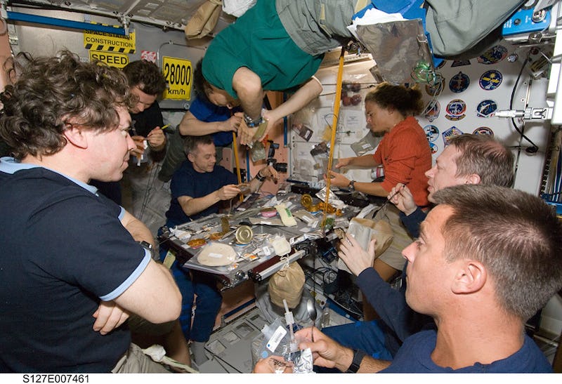  Eight of a total group of 13 astronauts and cosmonauts are pictured at meal time aboard the Interna...