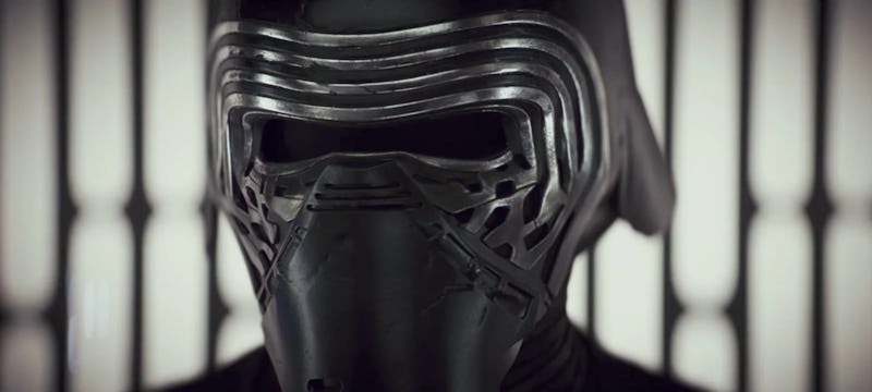 Close-up of a person wearing a dark, futuristic helmet with vertical, ribbed details, behind blurred...