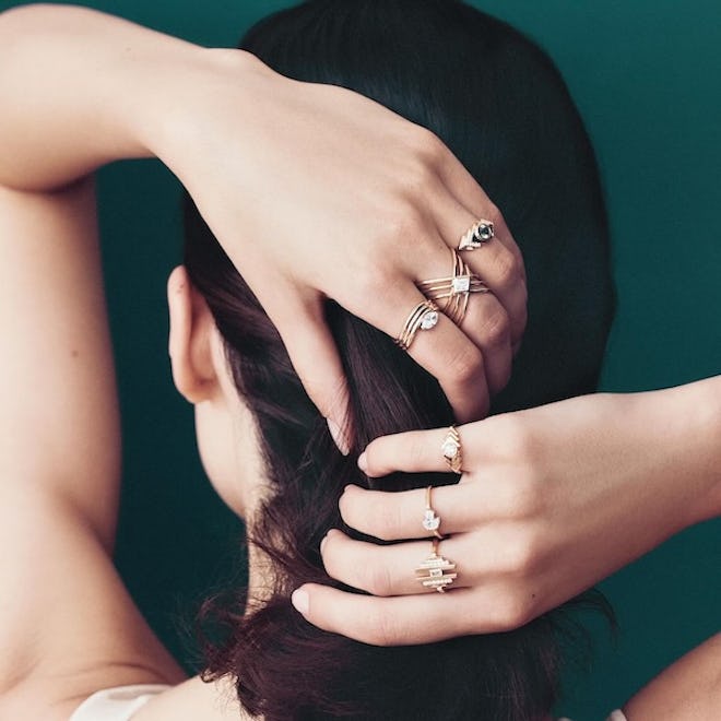 Selin Kent model wears multiple mixed metal rings on both hands