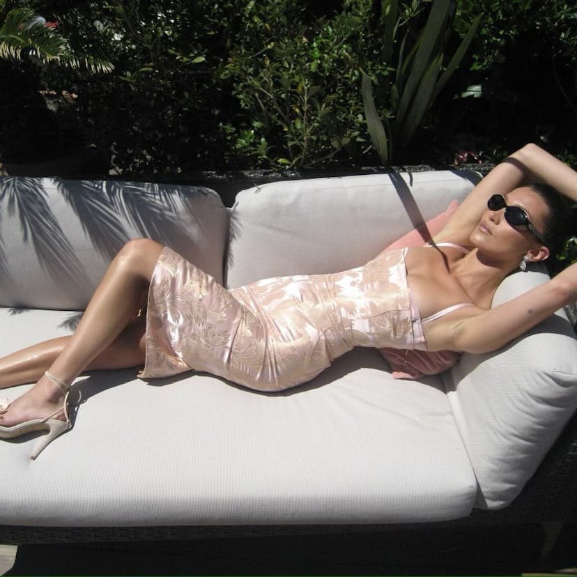 Bella Hadid wore a pale-pink brocade dress while creating promotional content for her perfume label,…