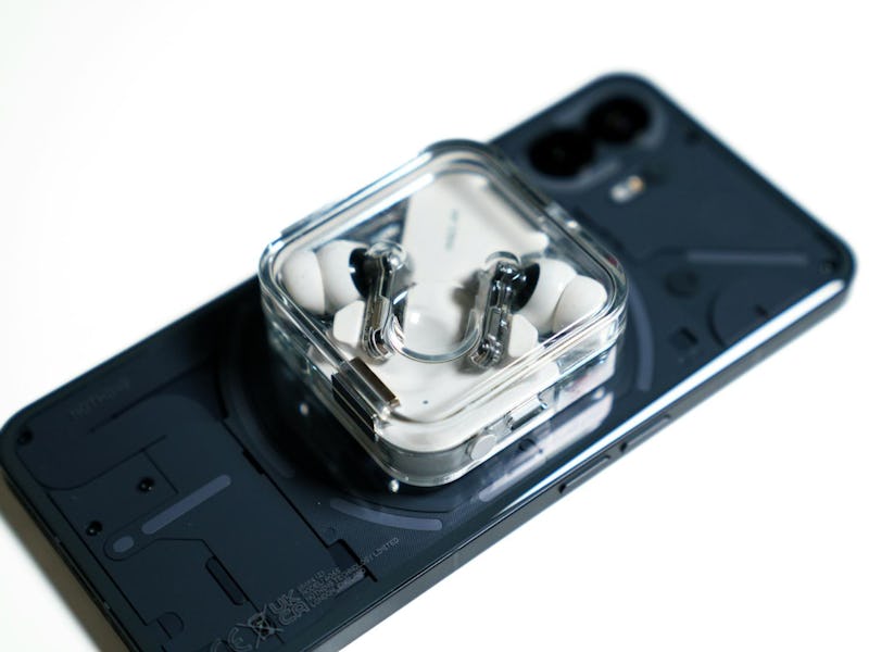 A Nothing Phone 2 reverse wireless charging a pair of Ear 2 wireless earbuds.