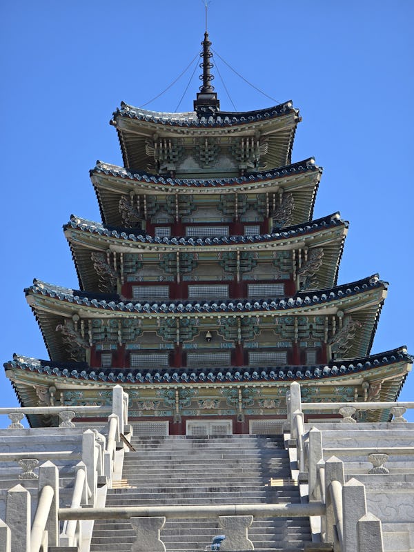 Traditional multi-tiered East Asian pagoda with blue roof details at the Gyeongbokgung Palace in Seo...