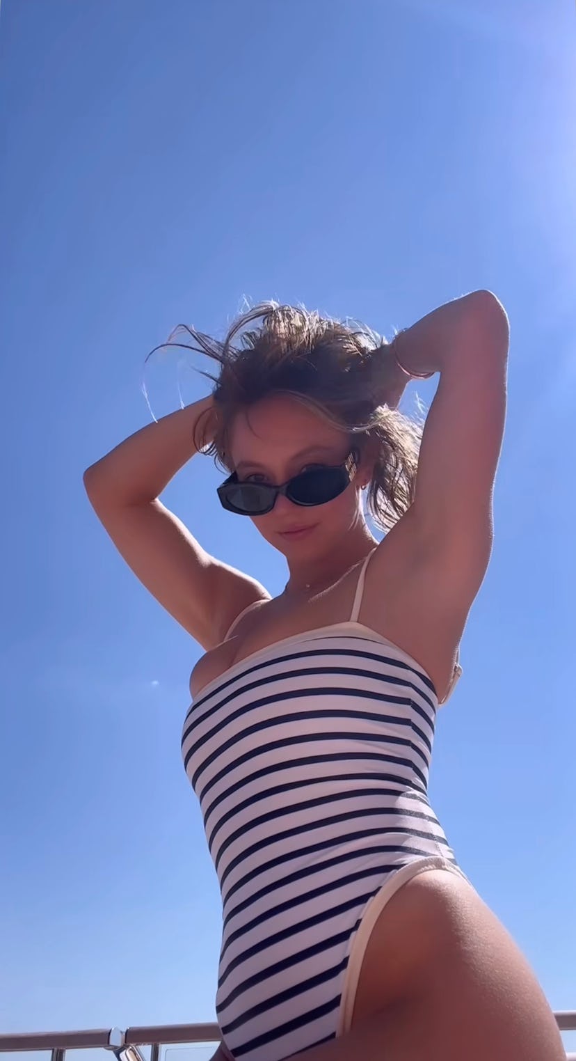 Sydney Sweeney wears a striped swimsuit. 