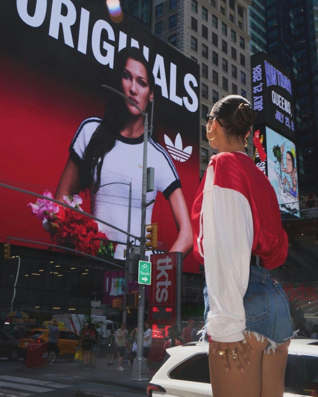 Bella Hadid wears a red sweatshirt and booty shorts in Midtown on July 11, 2024 in New York City.