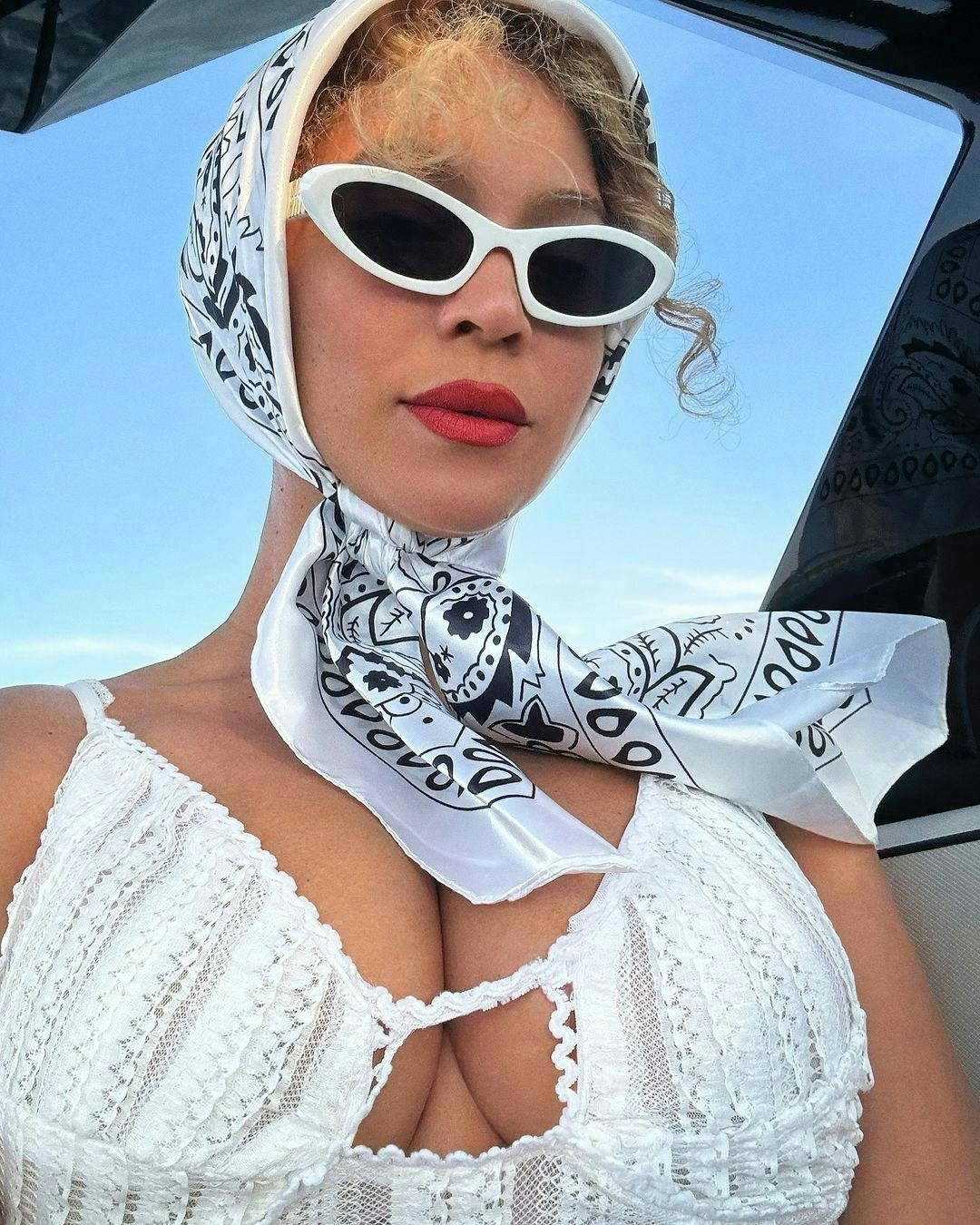Beyonce wears a white dress and head scarf in posh cowboycore.