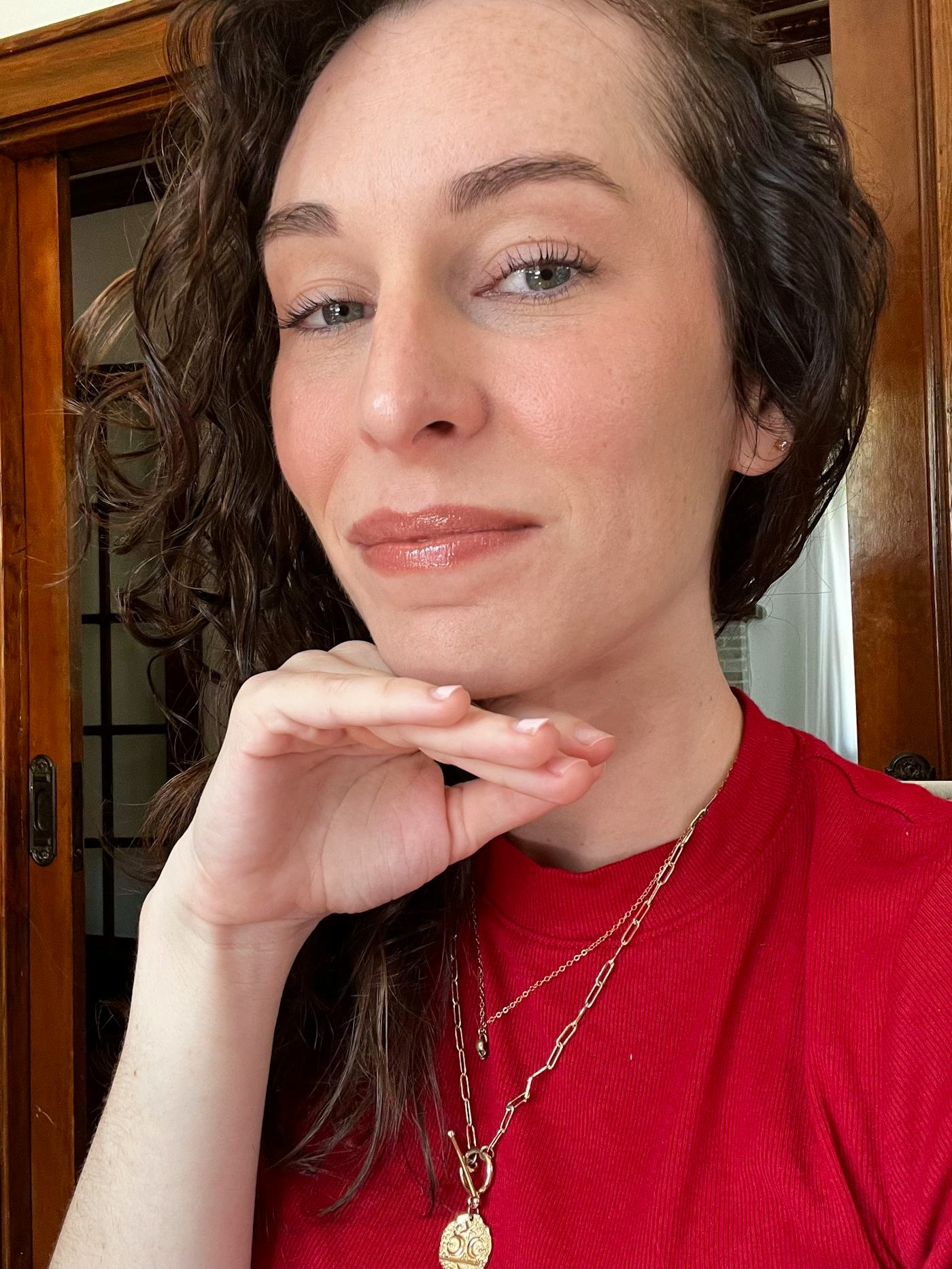 The author smiling to camera to show her 5-minute makeup routine that looks good on Zoom.