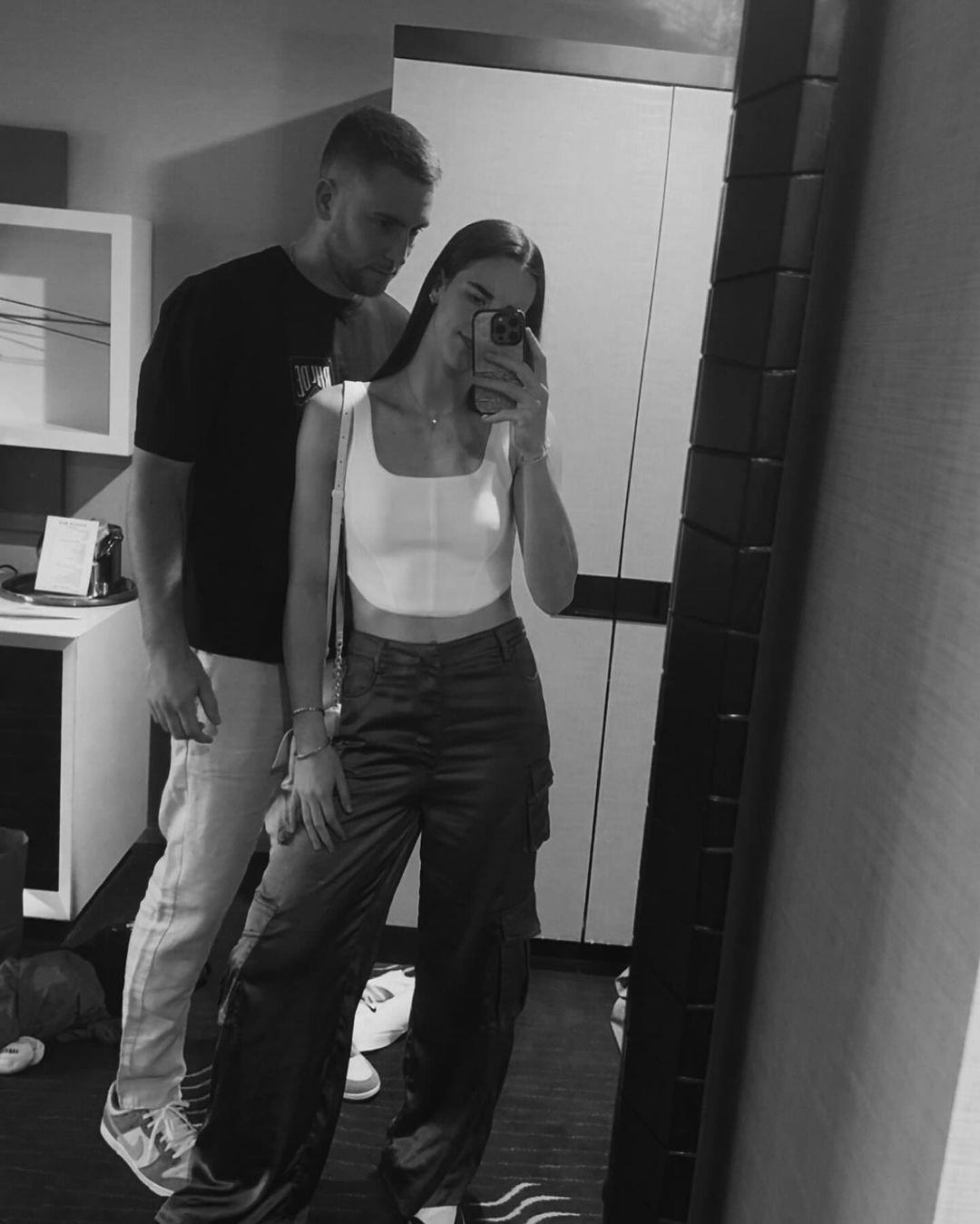 Caitlin Clark wearing a white bustier and cargo pants.