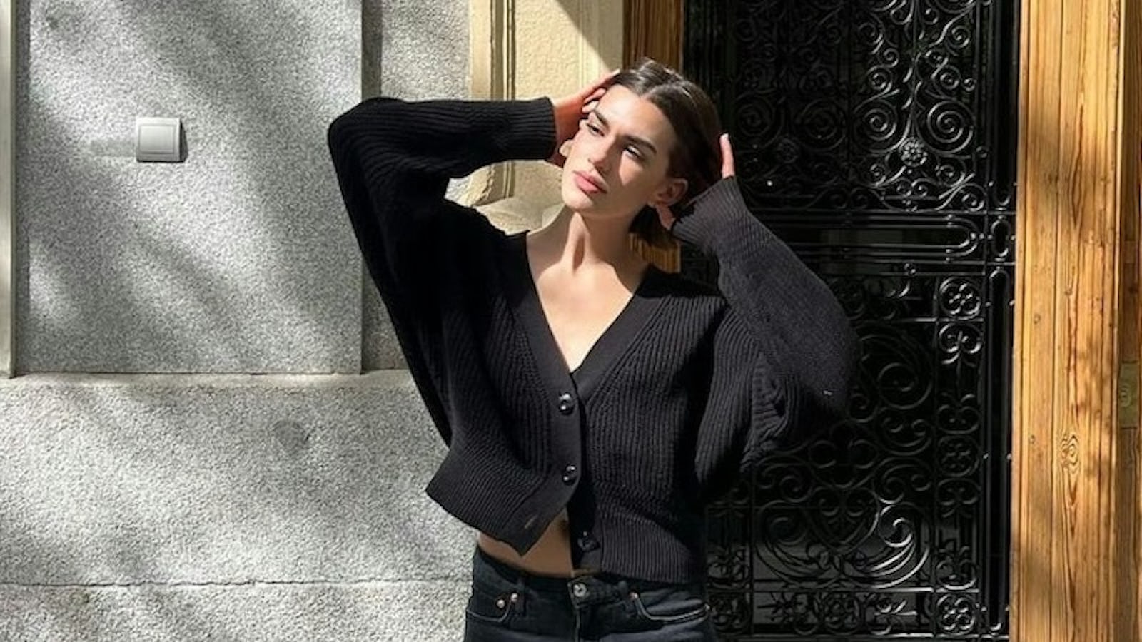 @valeriaminghelli wears cropped cardigan, black denim shorts, and tall black boots