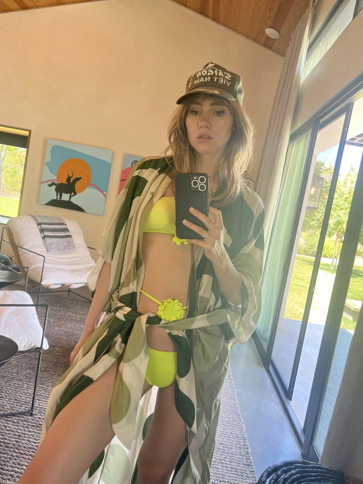 Suki Waterhouse posing in her green floral bikini