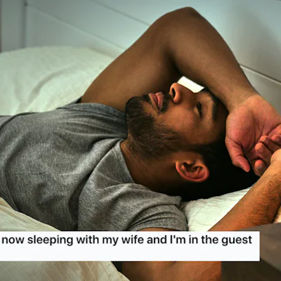 A man lying awake on a bed in a dimly lit room, looking distressed. A man on Reddit wants advice about his teens sleeping in his bedroom.